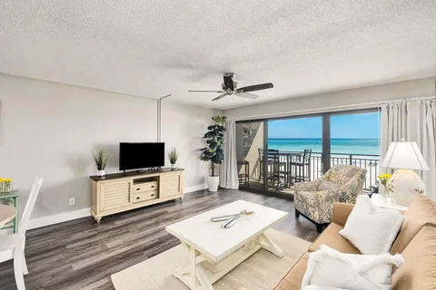a living room with furniture a flat screen tv and a large window