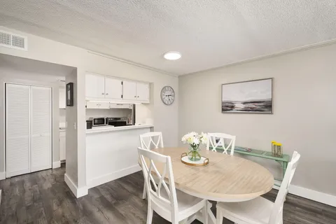 a kitchen with stainless steel appliances a dining table and chairs