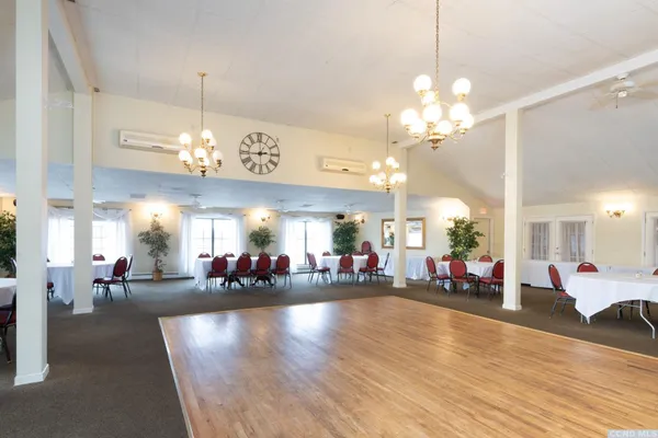 a view of a dining room and livingroom with furniture a chandelier