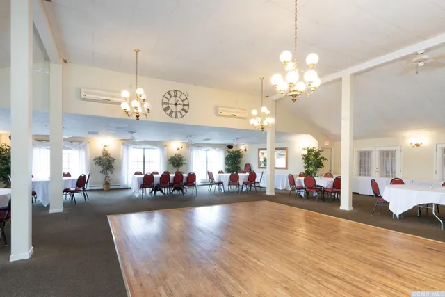 a view of a dining room and livingroom with furniture a chandelier