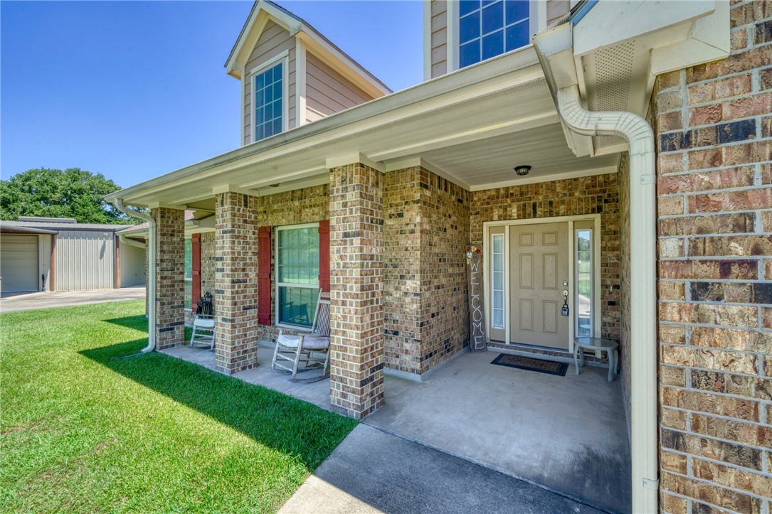 9945 Oxford Cemetery Road Madisonville, TX 77864 - Photo 6 of 42 Property entrance with a porch, brick siding, and a lawn