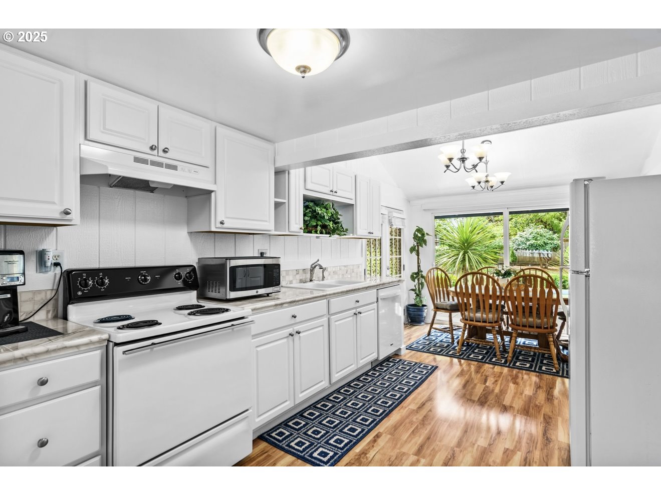 1995 Scott Road Springfield, OR 97477 - Photo 18 of 43 a kitchen with granite countertop a stove a sink dishwasher and white cabinets with wooden floor