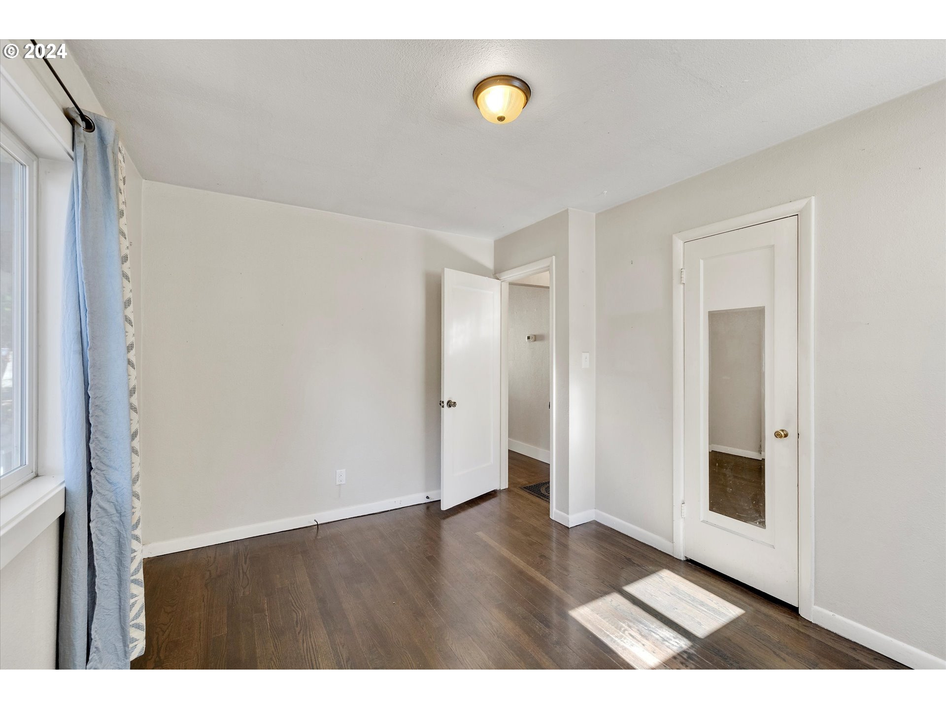 362 Southwest Oak Street Willamina, OR 97396 - Photo 14 of 34 a view of an empty room with wooden floor and windows