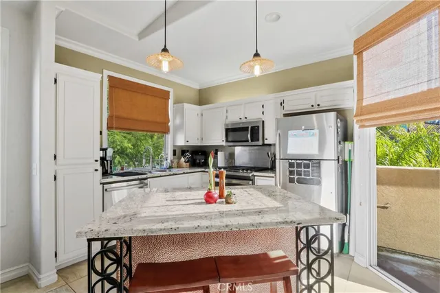 a kitchen with stainless steel appliances granite countertop a stove refrigerator and microwave
