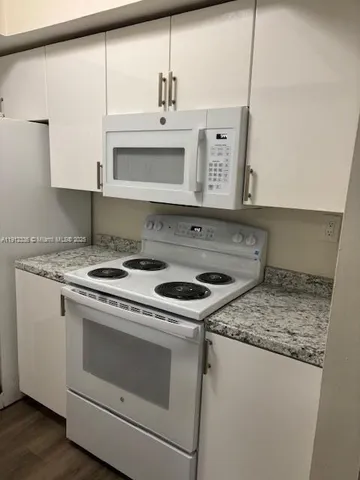 a white stove top oven sitting inside of a kitchen