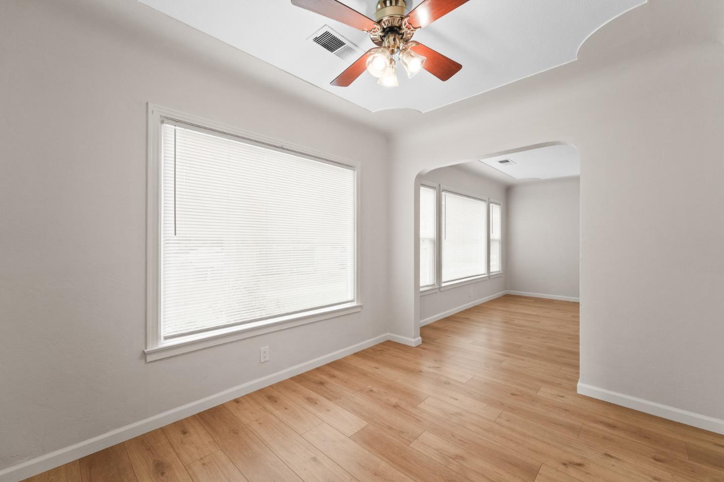 636 West 25th Street Merced, CA 95340 - Photo 15 of 31 an empty room with wooden floor chandelier fan and windows