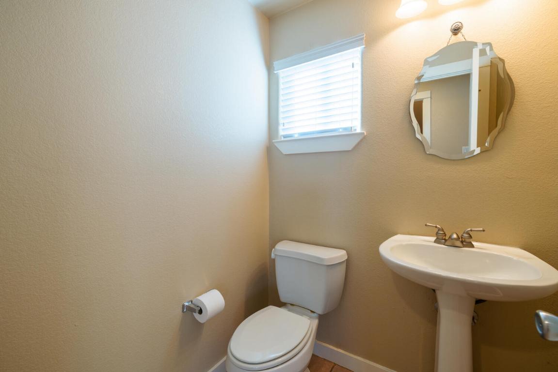 2102 Laura Court Round Rock, TX 78681 - Photo 13 of 32 a white toilet sitting next to a bathroom sink