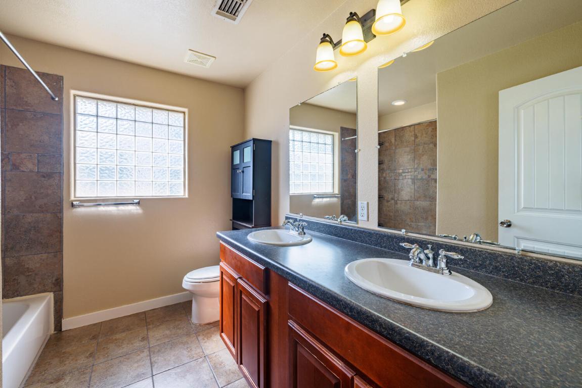 2102 Laura Court Round Rock, TX 78681 - Photo 27 of 32 a bathroom with a sink double vanity granite and a mirror