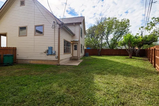 a front view of a house with yard and tree