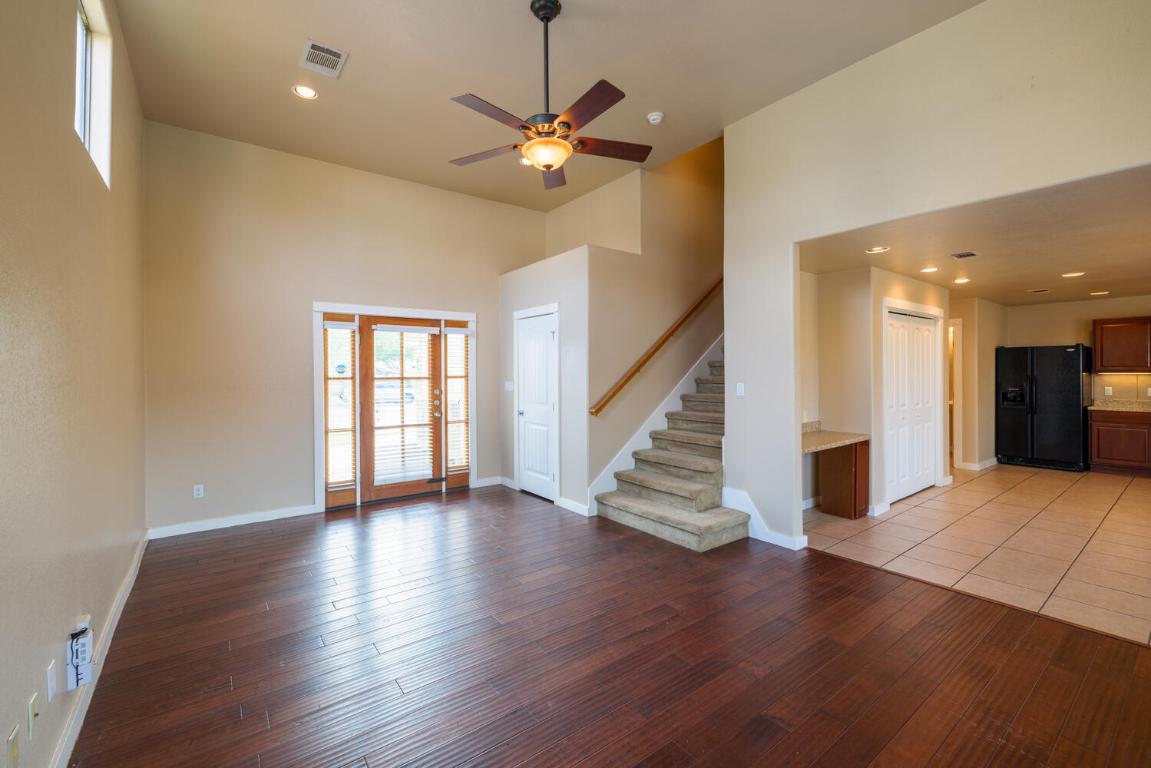 2102 Laura Court Round Rock, TX 78681 - Photo 4 of 32 a view of an empty room with wooden floor and a ceiling fan