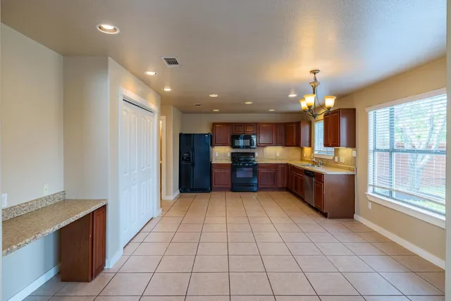 a large kitchen with a large counter top and stainless steel appliances