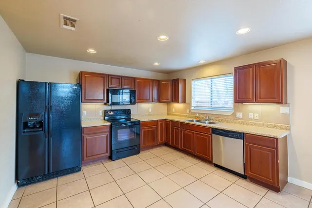 a large kitchen with stainless steel appliances granite countertop a stove sink and cabinets