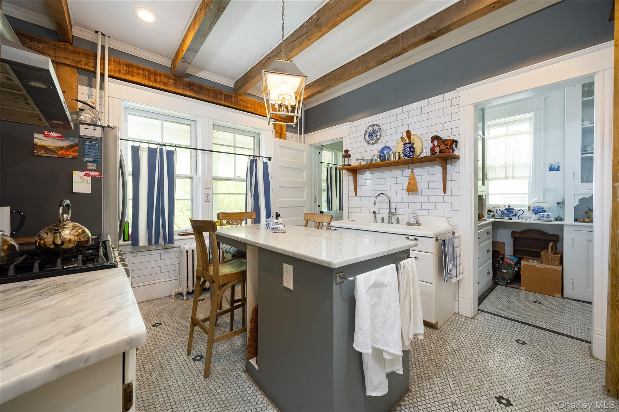 111 South Hamilton Street Poughkeepsie, NY 12601 - Photo 12 of 33 Kitchen featuring exposed wood beams, subway tile backsplash, marble-look countertops, and an integrated kitchen island with seating