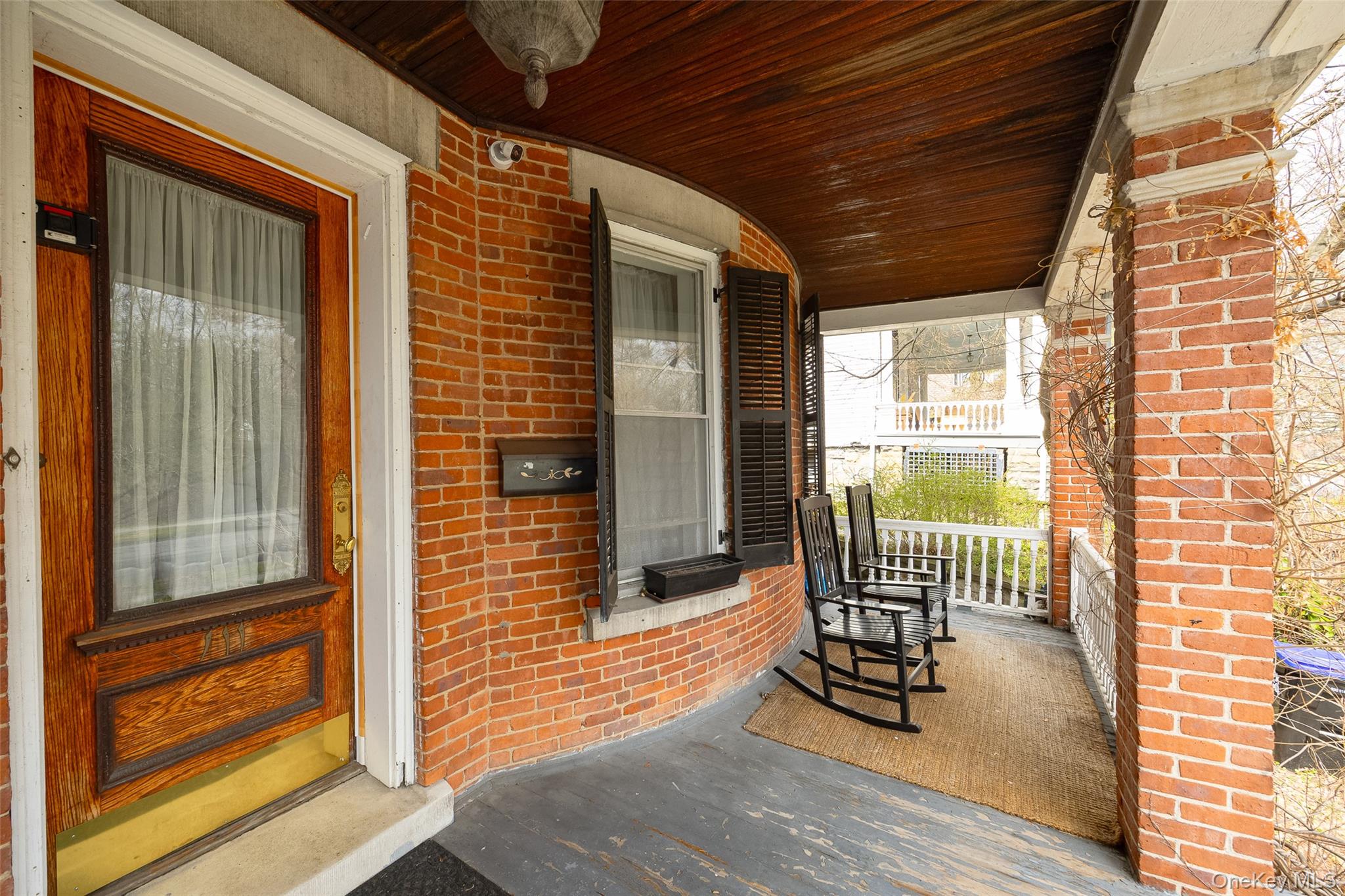 111 South Hamilton Street Poughkeepsie, NY 12601 - Photo 2 of 33 Brick façade porch with a prominent wood-panel door featuring a glass insert and brass kickplate