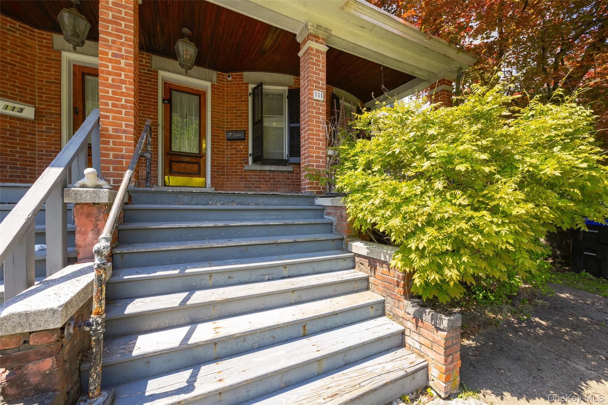 111 South Hamilton Street Poughkeepsie, NY 12601 - Photo 3 of 33 Brick exterior with a covered porch featuring a wood-finish ceiling, decorative overhead lighting, and a paneled entry door
