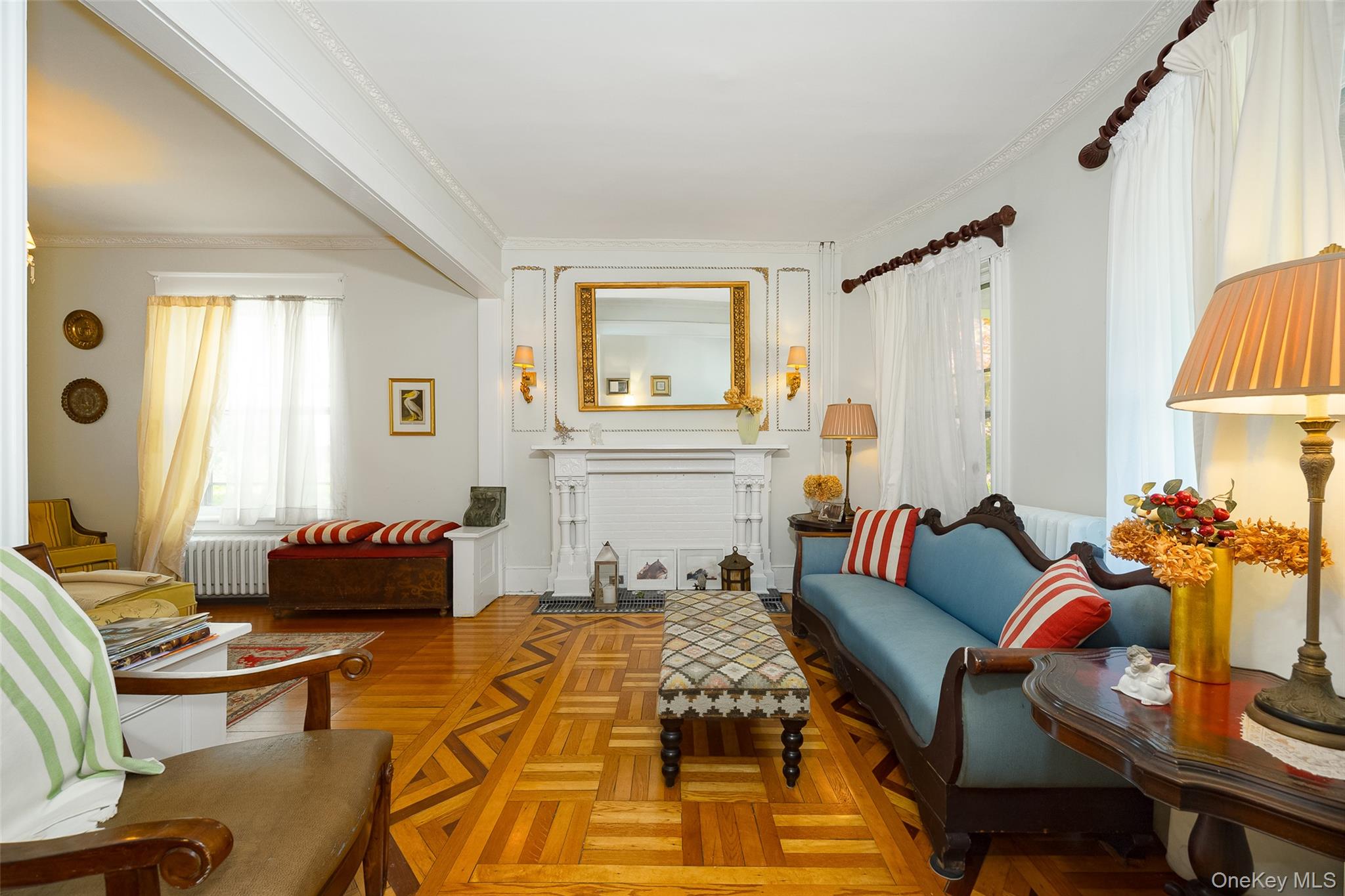 111 South Hamilton Street Poughkeepsie, NY 12601 - Photo 5 of 33 Living space featuring parquet wood-finish flooring, an ornate fireplace mantel with a golden framed mirror, ceiling crown molding, and decorative wall sconces