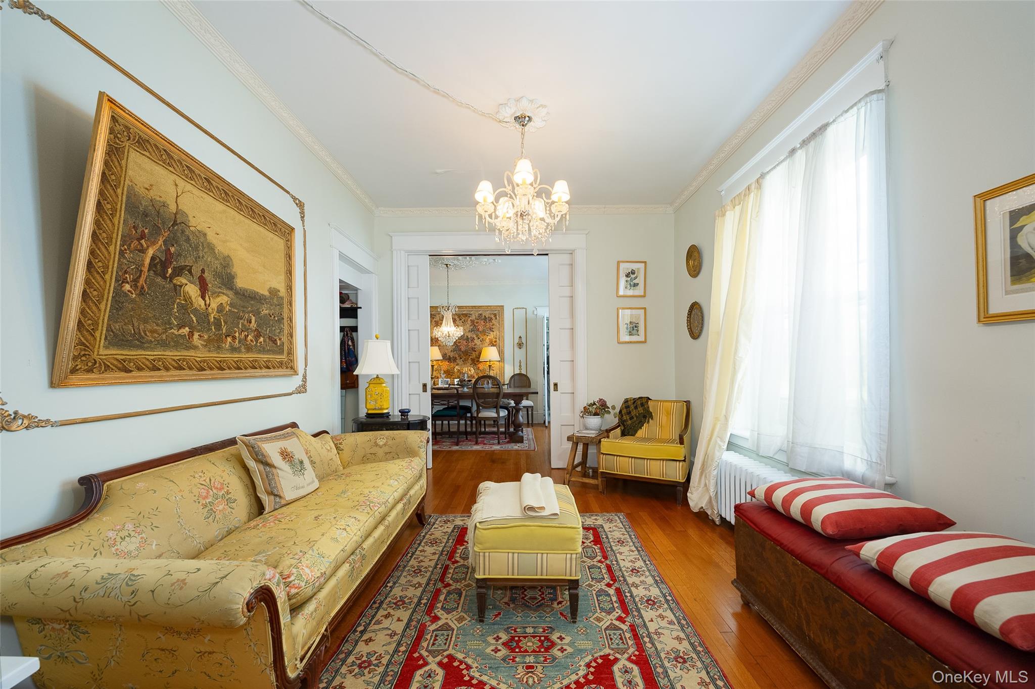 111 South Hamilton Street Poughkeepsie, NY 12601 - Photo 6 of 33 Living area featuring wood-finish flooring, an ornate crown molding, a decorative ceiling medallion, and a chandelier