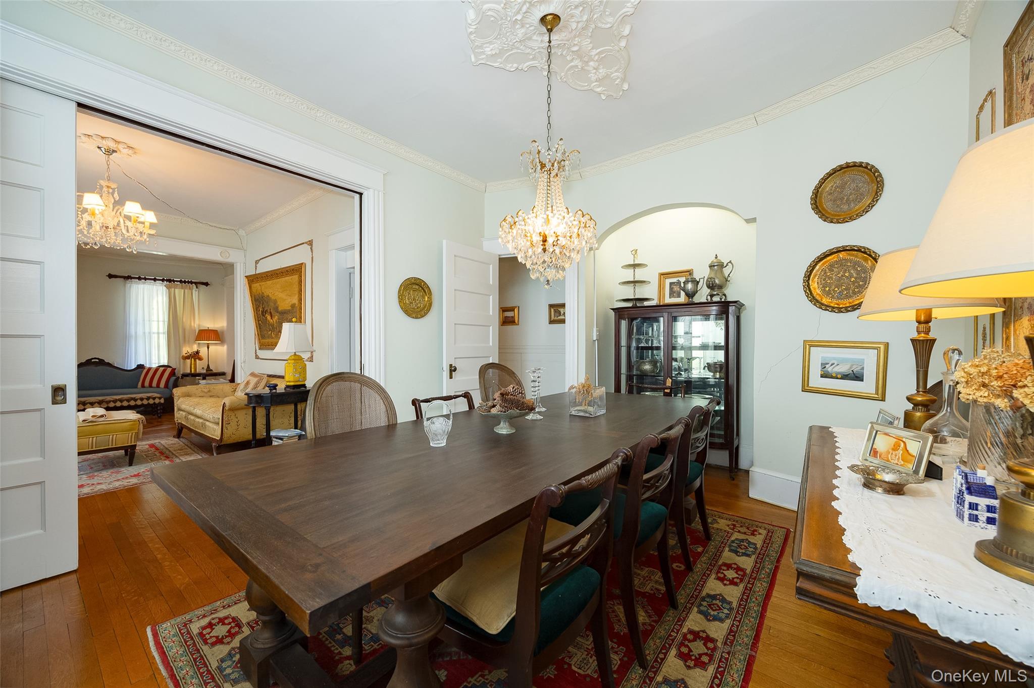 111 South Hamilton Street Poughkeepsie, NY 12601 - Photo 9 of 33 Formal dining space featuring hardwood flooring, an ornate ceiling medallion with a crystal chandelier, and an arched doorway