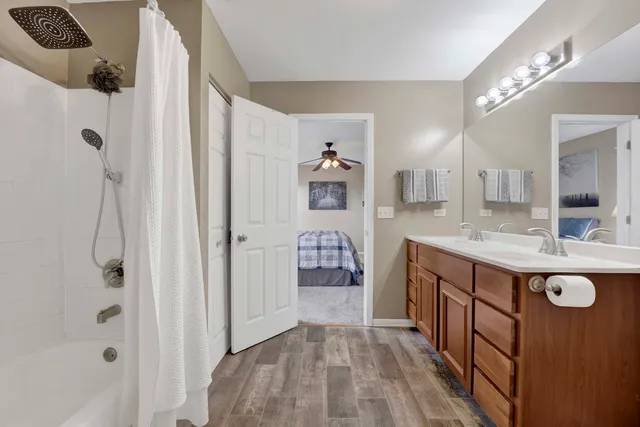 a bathroom with a sink a toilet a mirror and shower