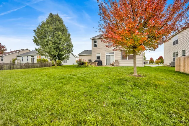 a view of a house with a big yard and large trees