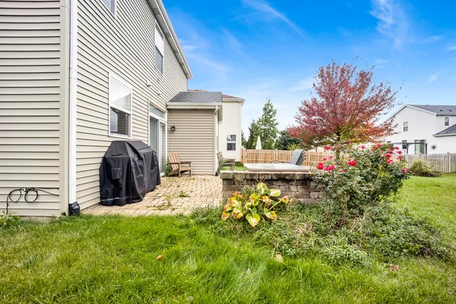 a view of a chair and table in backyard of the house