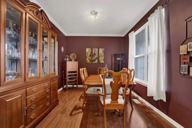 a dining room with furniture a chandelier and wooden floor