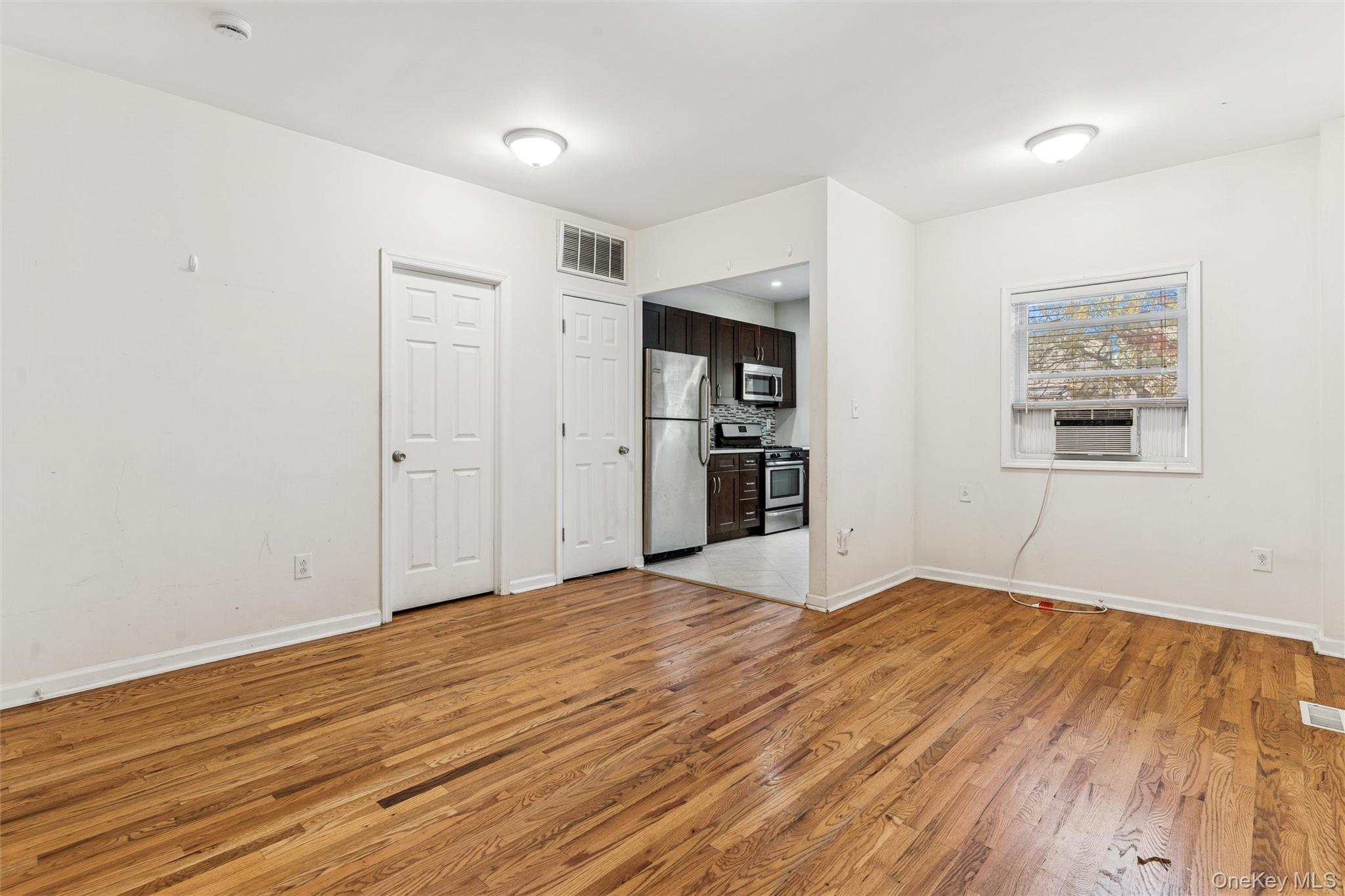 91-25 90th Street Queens, NY 11421 - Photo 11 of 30 Unfurnished living room with light wood-type flooring