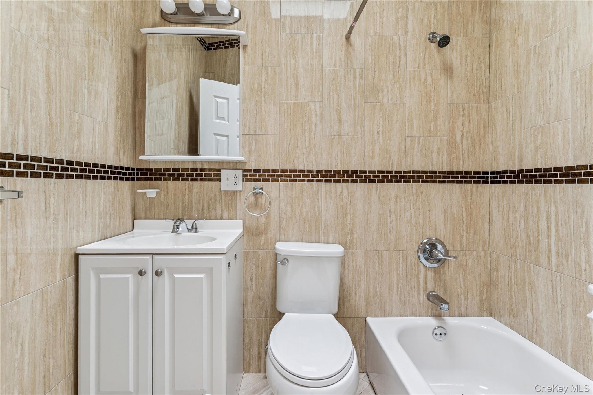 91-25 90th Street Queens, NY 11421 - Photo 16 of 30 Bathroom featuring tile walls, vanity, and bathing tub / shower combination
