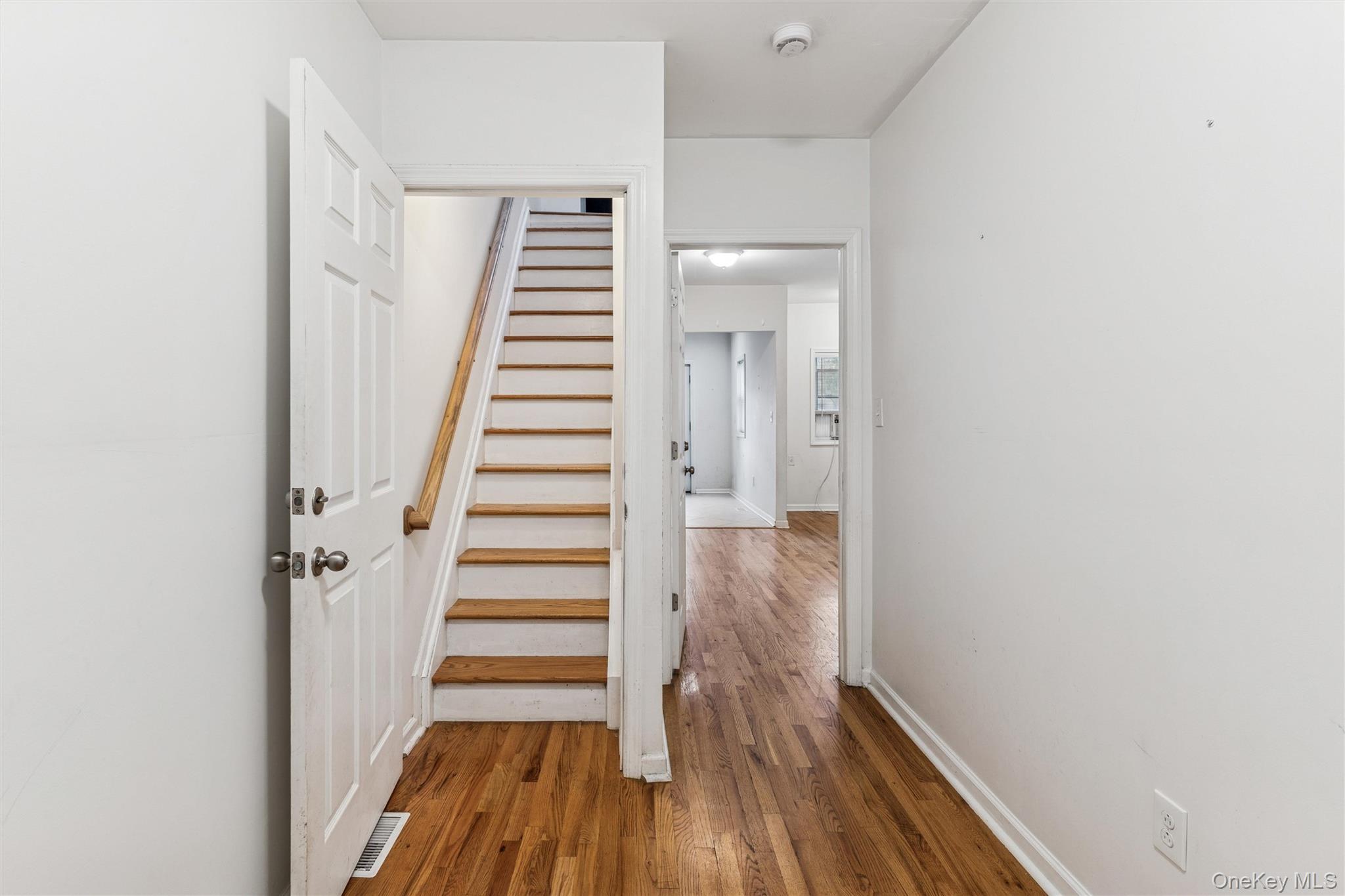 91-25 90th Street Queens, NY 11421 - Photo 4 of 30 Hallway featuring stairway and dark wood-type flooring