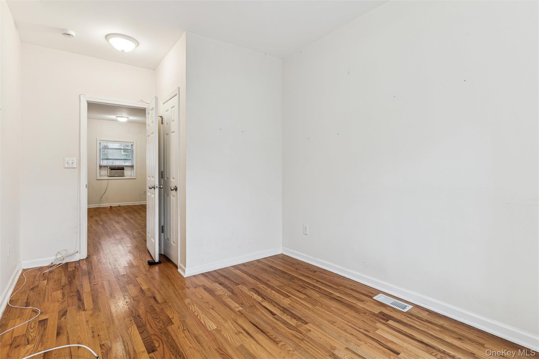 91-25 90th Street Queens, NY 11421 - Photo 6 of 30 Unfurnished room with light wood-style floors and cooling unit