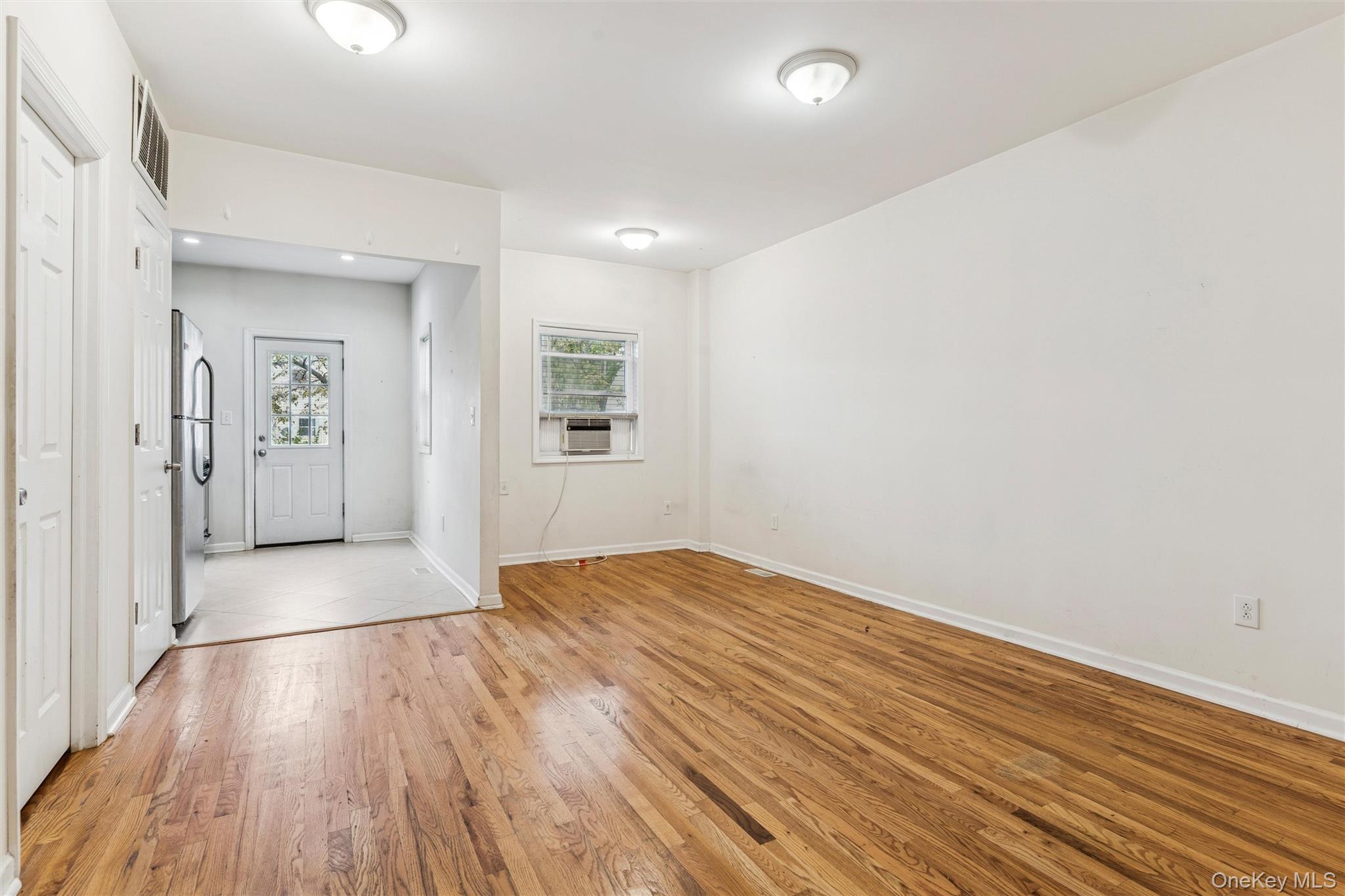 91-25 90th Street Queens, NY 11421 - Photo 8 of 30 Foyer entrance with light wood-style floors and cooling unit