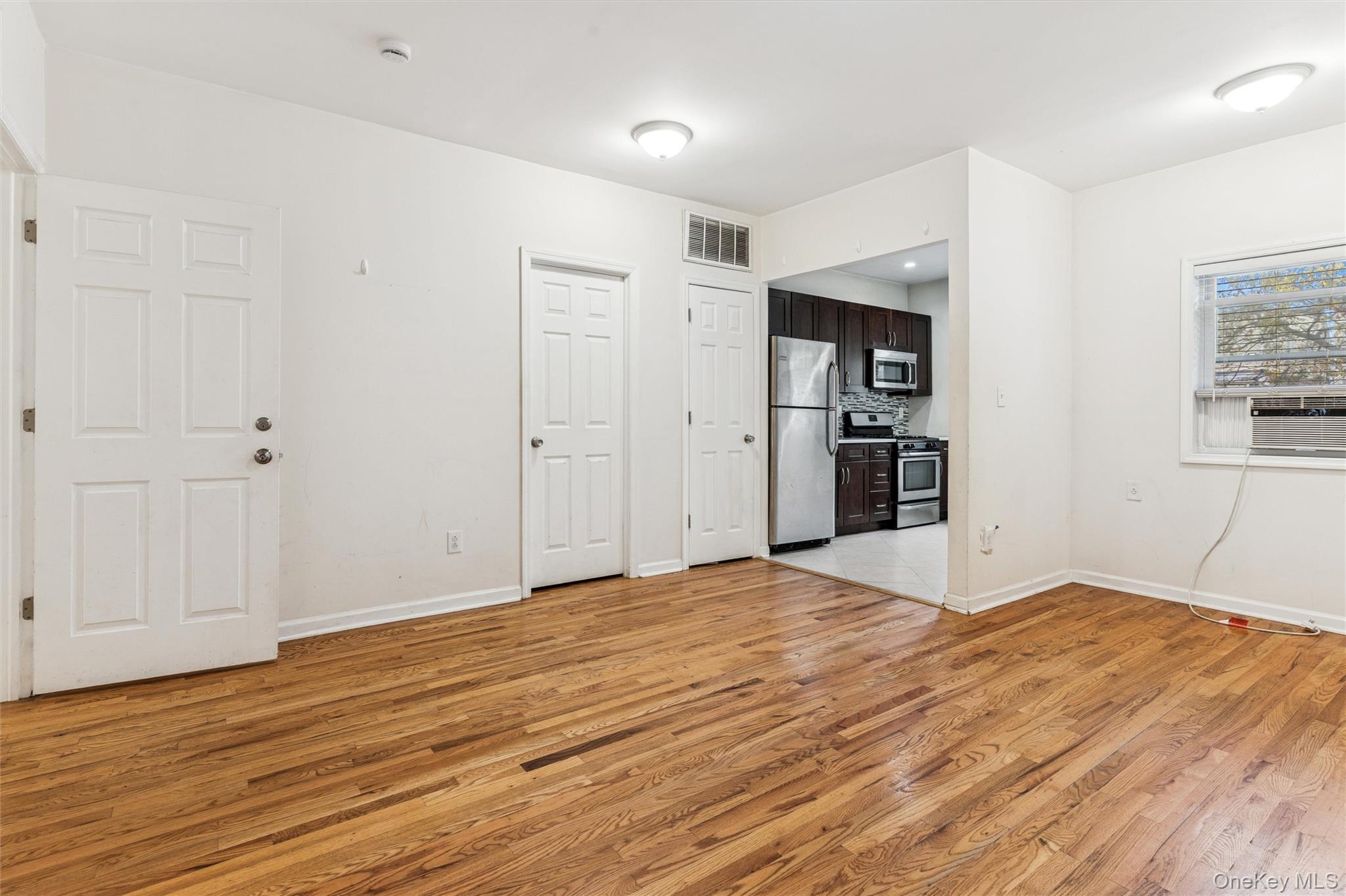 91-25 90th Street Queens, NY 11421 - Photo 10 of 30 Unfurnished living room with light wood-style flooring
