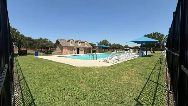 a view of a swimming pool with a garden and trees