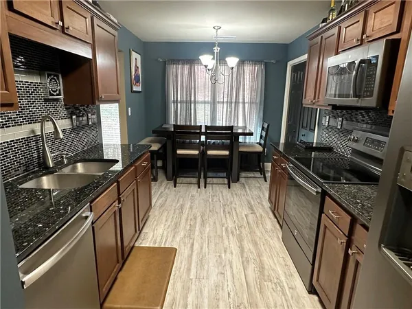 a kitchen with a sink stove top oven and cabinets