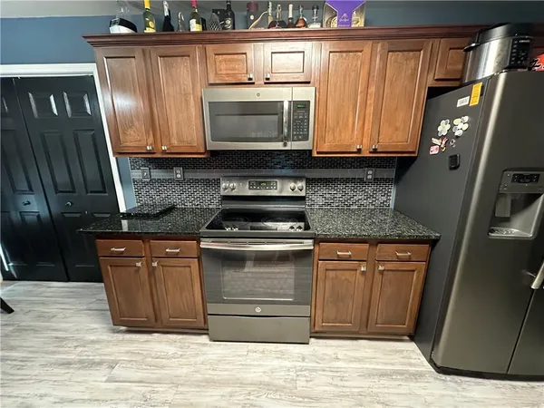 a kitchen with stainless steel appliances granite countertop a stove and a microwave