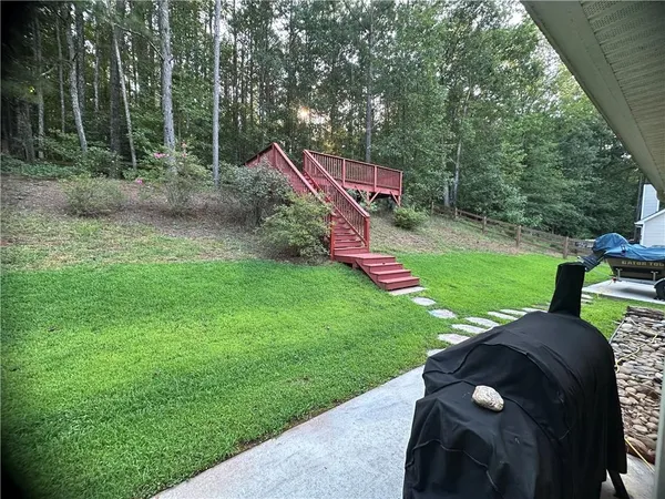 a view of a park with large trees and a barn