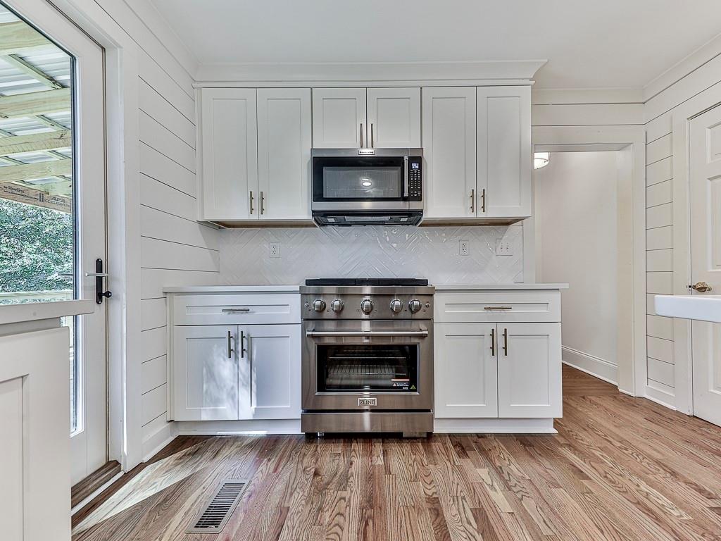633 Butterworth Road Canton, GA 30114 - Photo 12 of 55 a kitchen with stainless steel appliances a stove and white cabinets