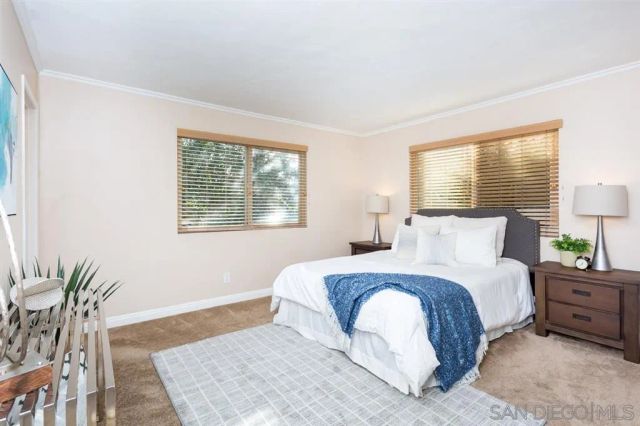 a large bedroom with a bed and wooden floor