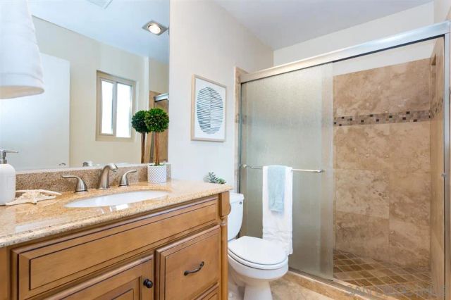 a bathroom with a granite countertop sink toilet and shower