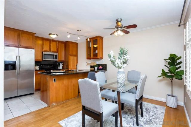 a dining room with furniture a kitchen view and wooden floor