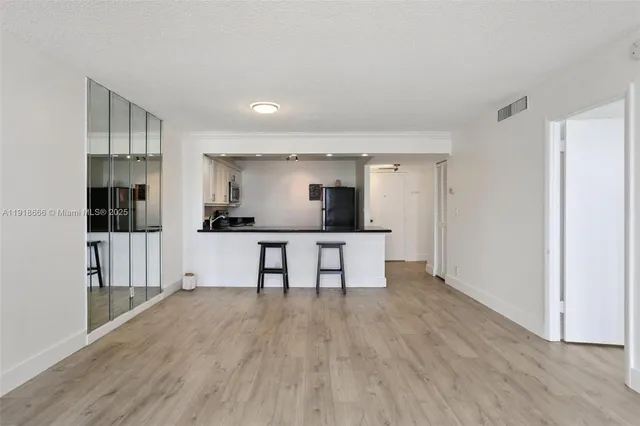 a living room with stainless steel appliances kitchen island furniture and wooden floor