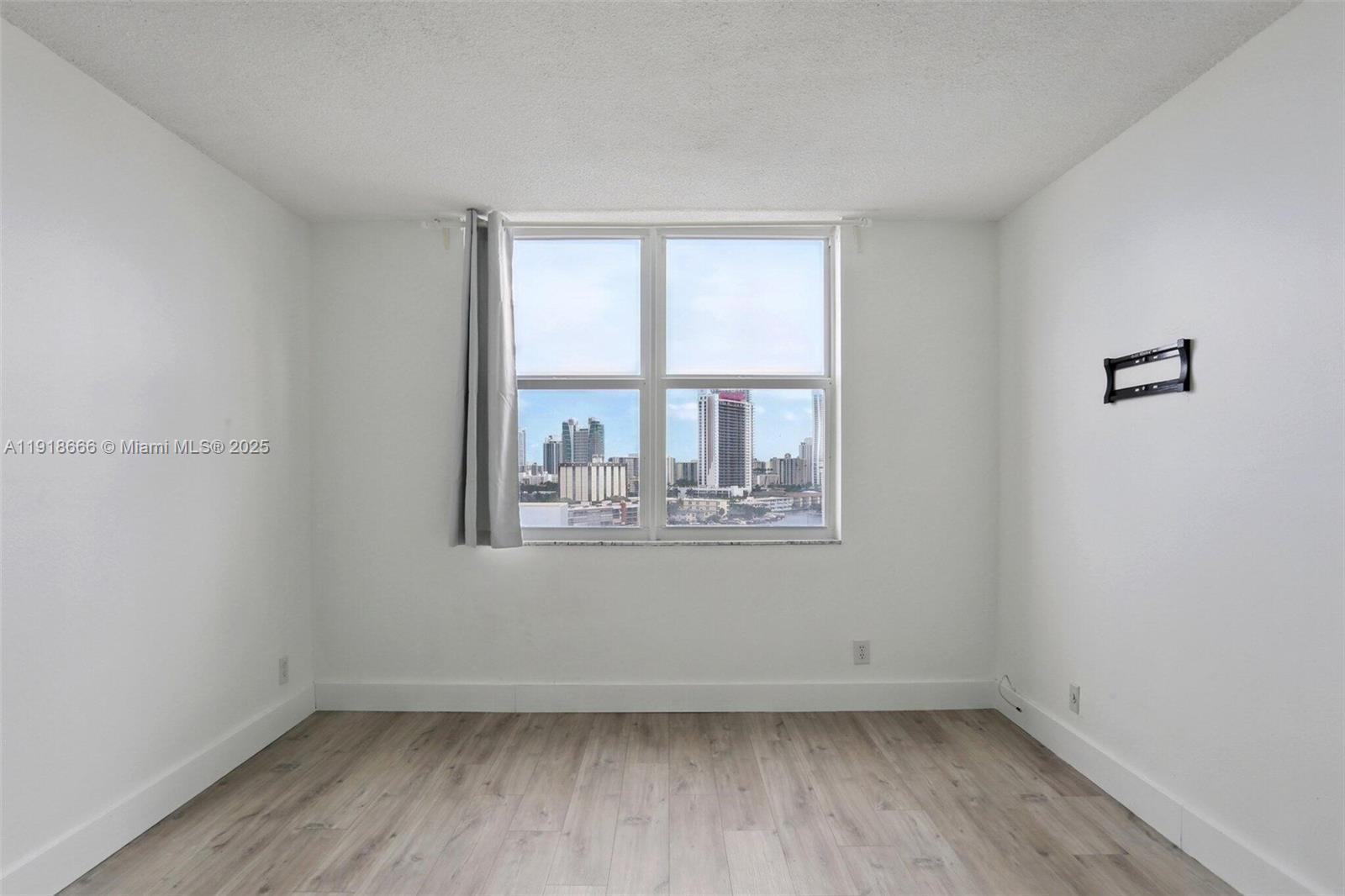 427 Golden Isles Drive, Unit 11F Hallandale Beach, FL 33009 - Photo 15 of 24 an empty room with wooden floor and windows