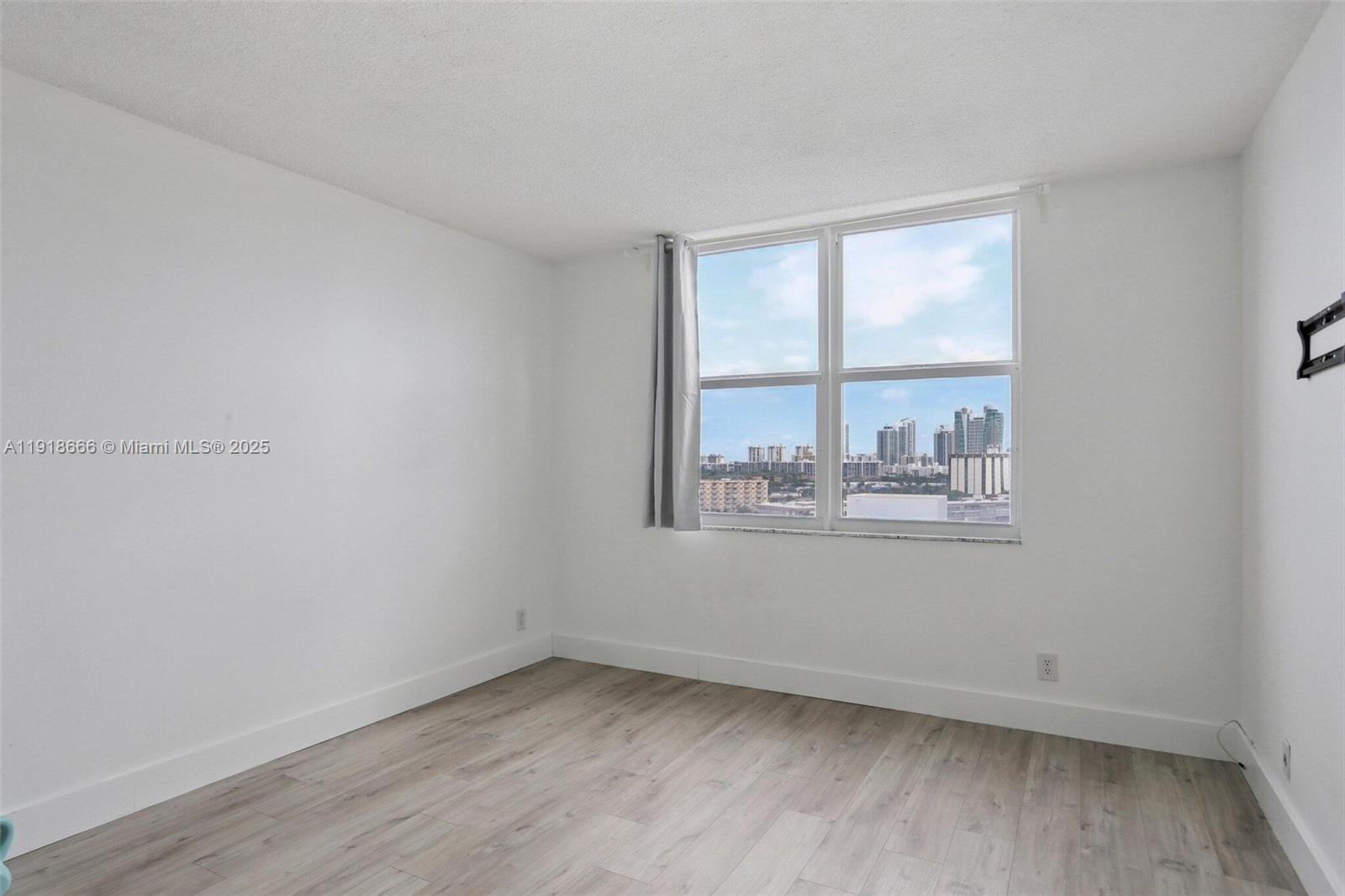 427 Golden Isles Drive, Unit 11F Hallandale Beach, FL 33009 - Photo 16 of 24 an empty room with a window