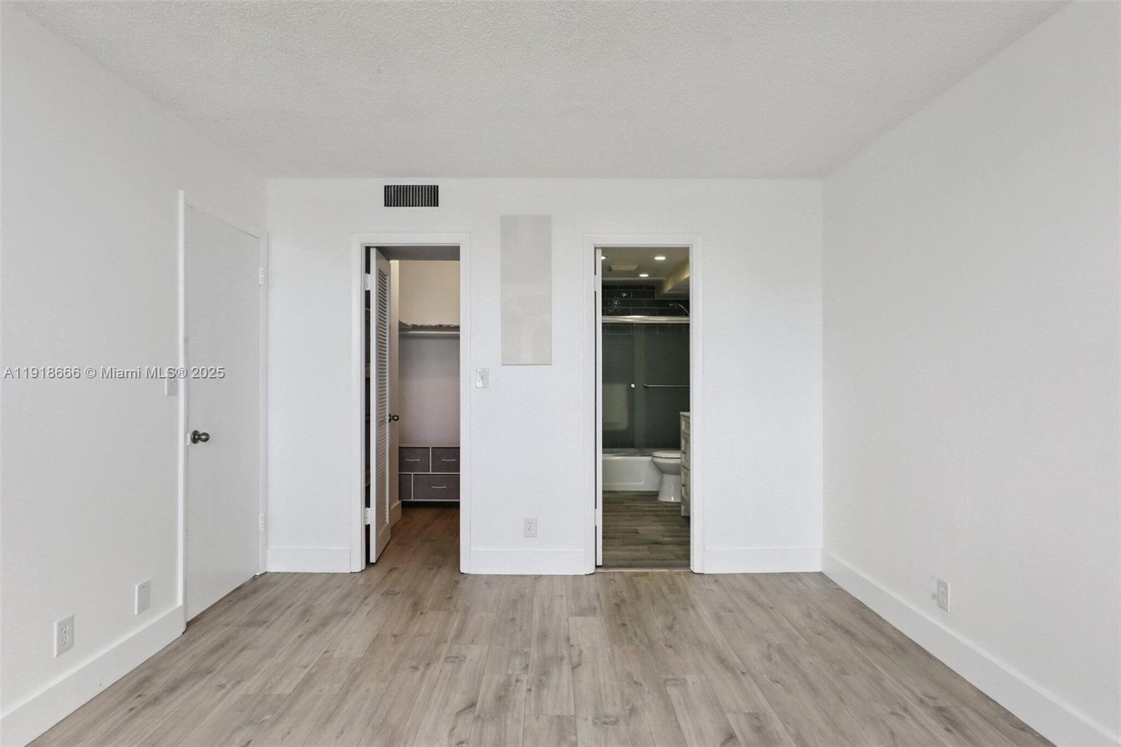 427 Golden Isles Drive, Unit 11F Hallandale Beach, FL 33009 - Photo 18 of 24 an empty room with wooden floor and closet