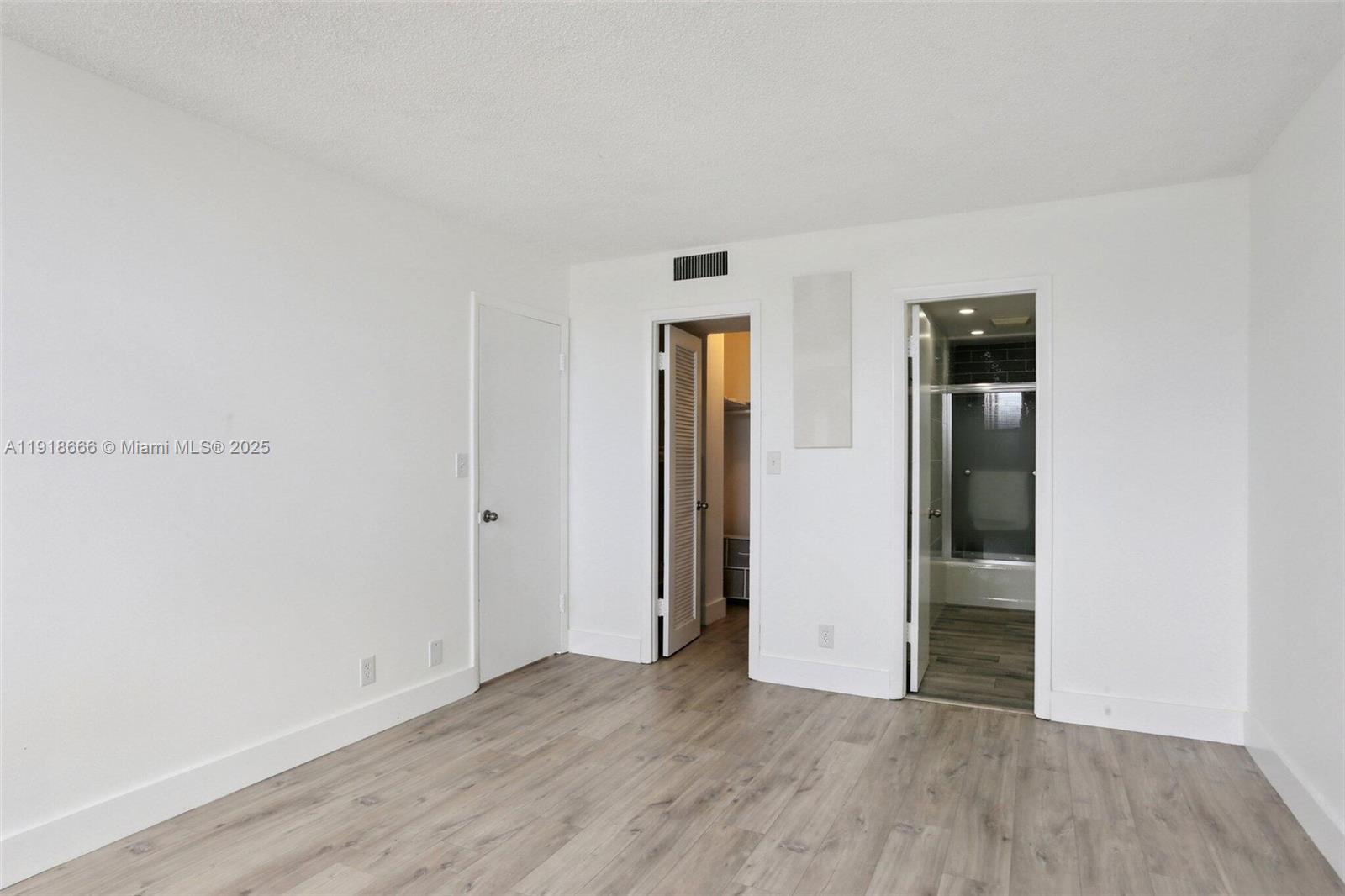 427 Golden Isles Drive, Unit 11F Hallandale Beach, FL 33009 - Photo 19 of 24 an empty room with wooden floor and closet