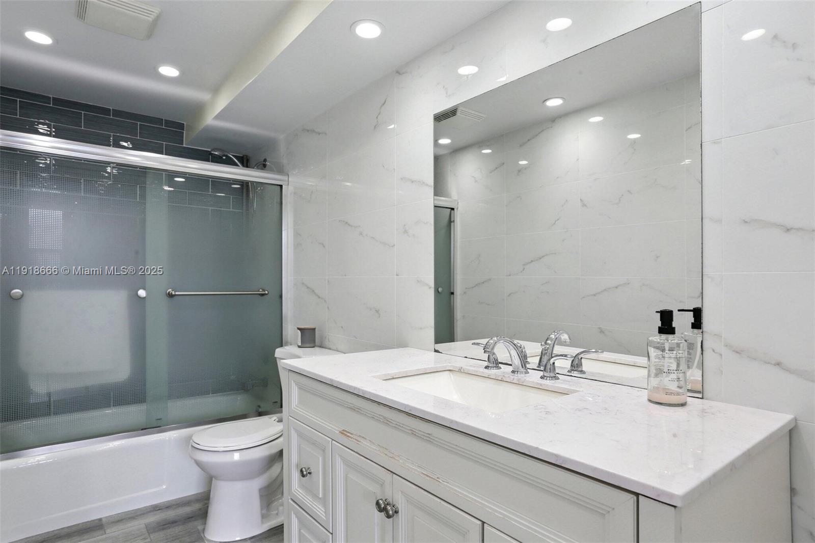 427 Golden Isles Drive, Unit 11F Hallandale Beach, FL 33009 - Photo 20 of 24 a bathroom with a sink toilet and shower