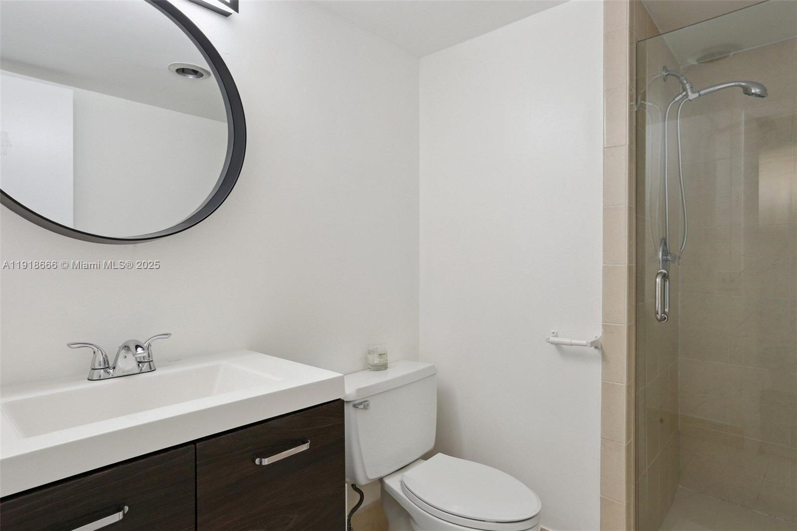 427 Golden Isles Drive, Unit 11F Hallandale Beach, FL 33009 - Photo 21 of 24 a bathroom with a sink a toilet and a mirror