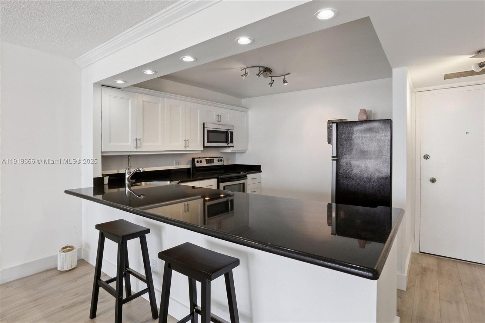 427 Golden Isles Drive, Unit 11F Hallandale Beach, FL 33009 - Photo 6 of 24 a kitchen with stainless steel appliances a sink counter space and cabinets