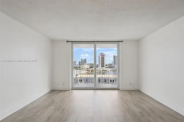 an empty room with wooden floor and door