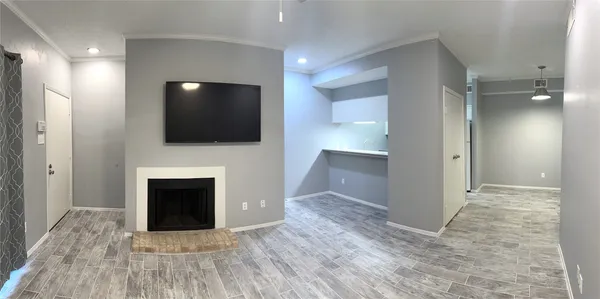 a view of an empty room with fire place and a window